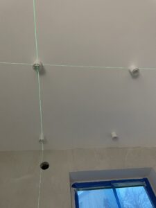 Montaż lamp punktowych za pomocą poziomicy laserowej przez elektryka